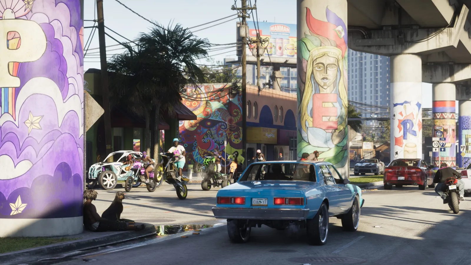A classic blue muscle car on a mural-covered Vice City street in GTA 6, with pedestrians around